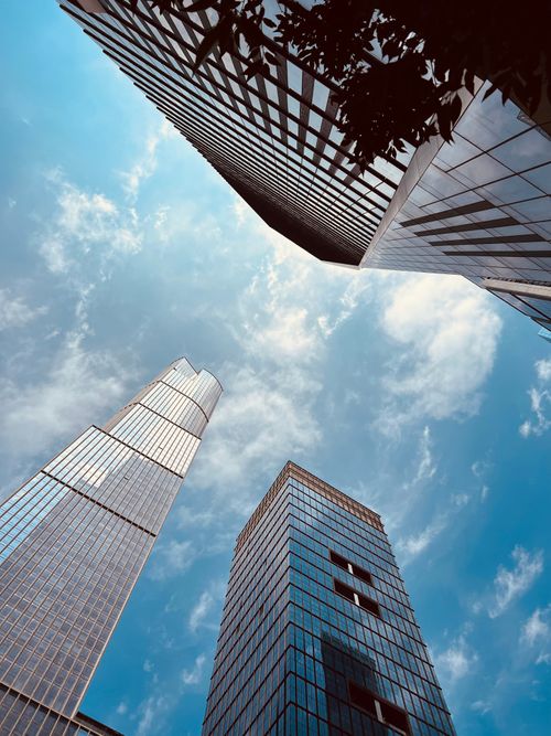 Free Stunning view of modern skyscrapers against a bright blue sky with clouds. Stock Photo