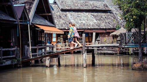 Two Person Walking on Bridge