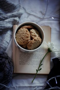 Top view of a bowl of homemade cookies on an open book, perfect for a cozy morning.