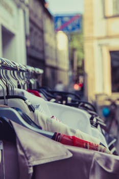 Shallow Focus Photography of Shirts Hang on Silver Clothes Rack Under Sunny Sky