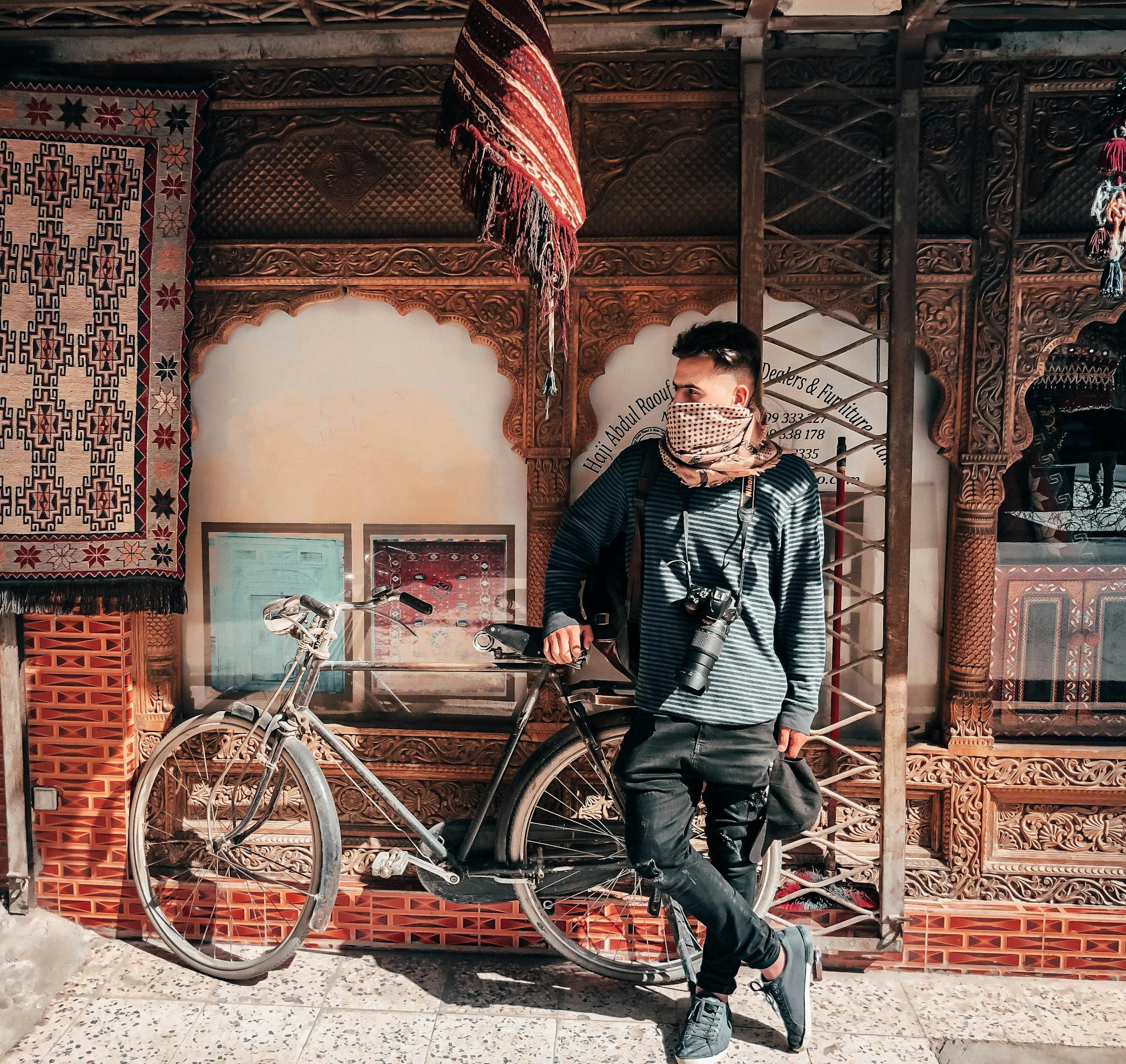 Young traveler with bicycle in colorful urban setting. Stylish and adventurous.