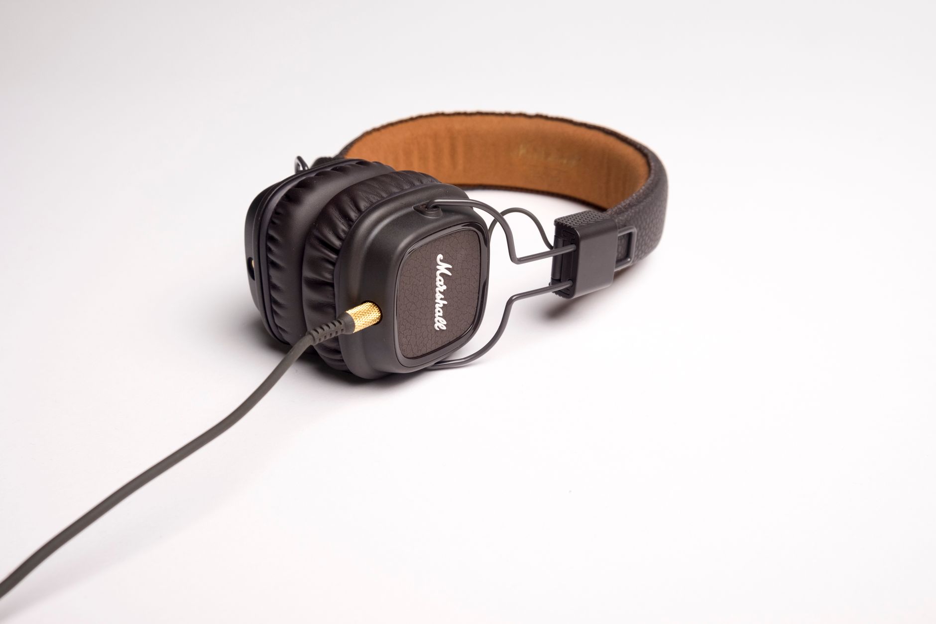 High-quality black headphones featuring leather ear pads and a curly audio cable, ideal for music listening.