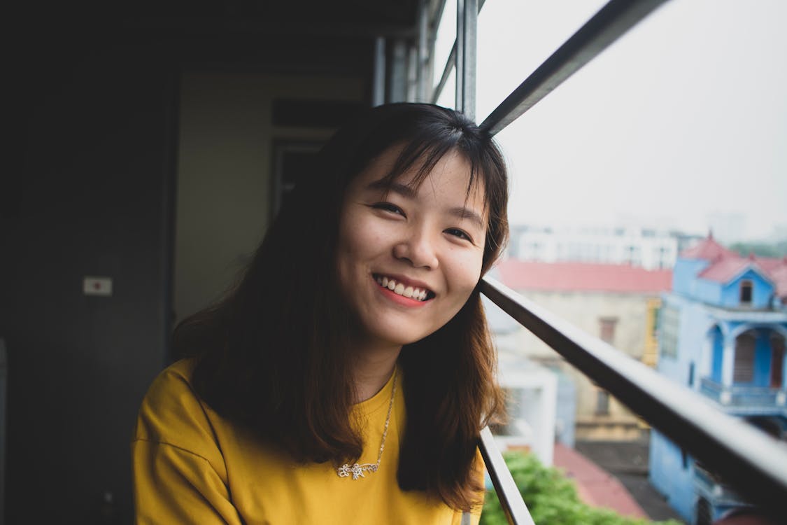 Woman Smiling Near at Windowpane