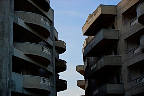 2 Brown High Rise Building Facing Each Other at Daytime