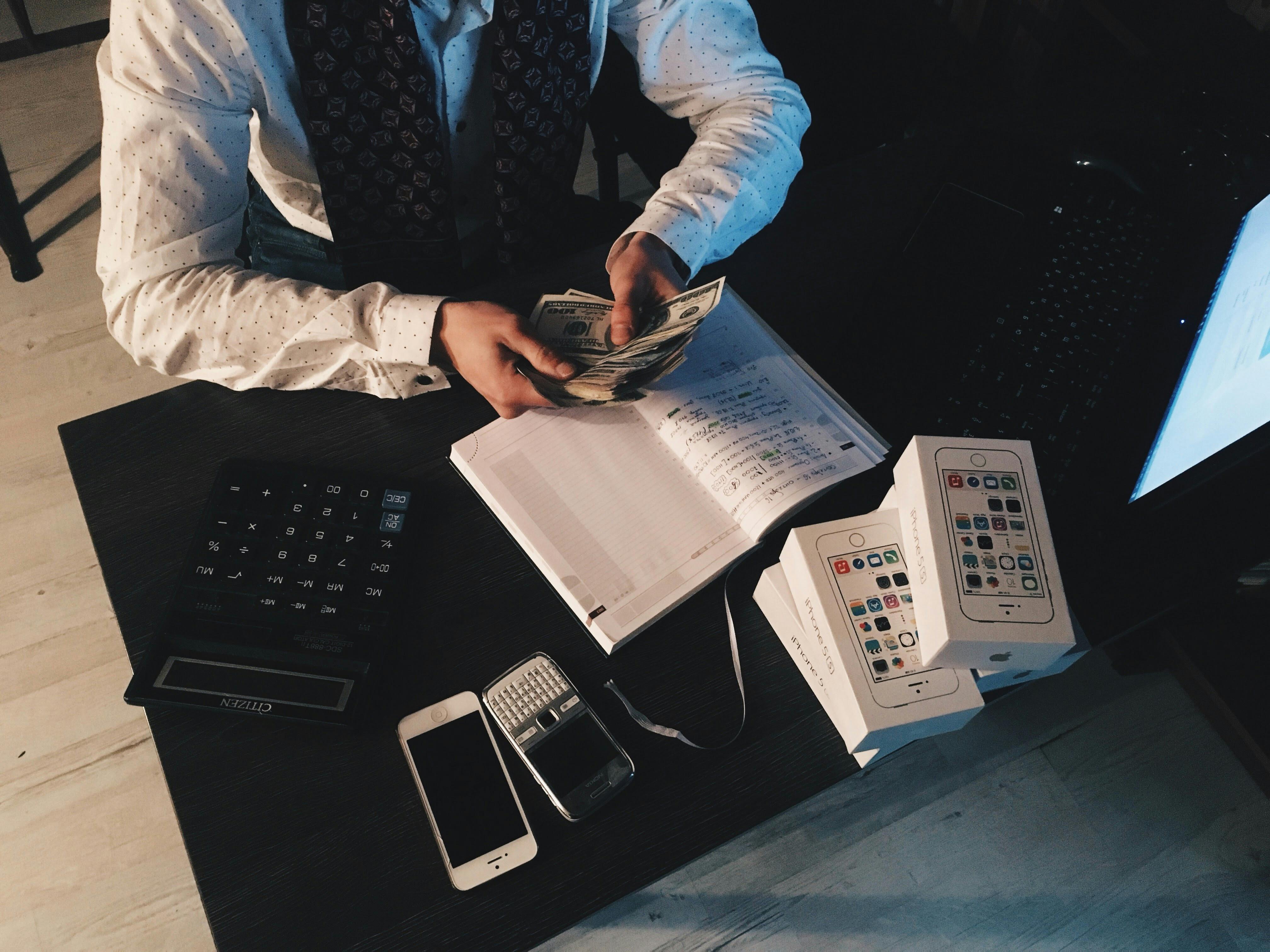 A man counting money on his desk. | Photo: Pexels