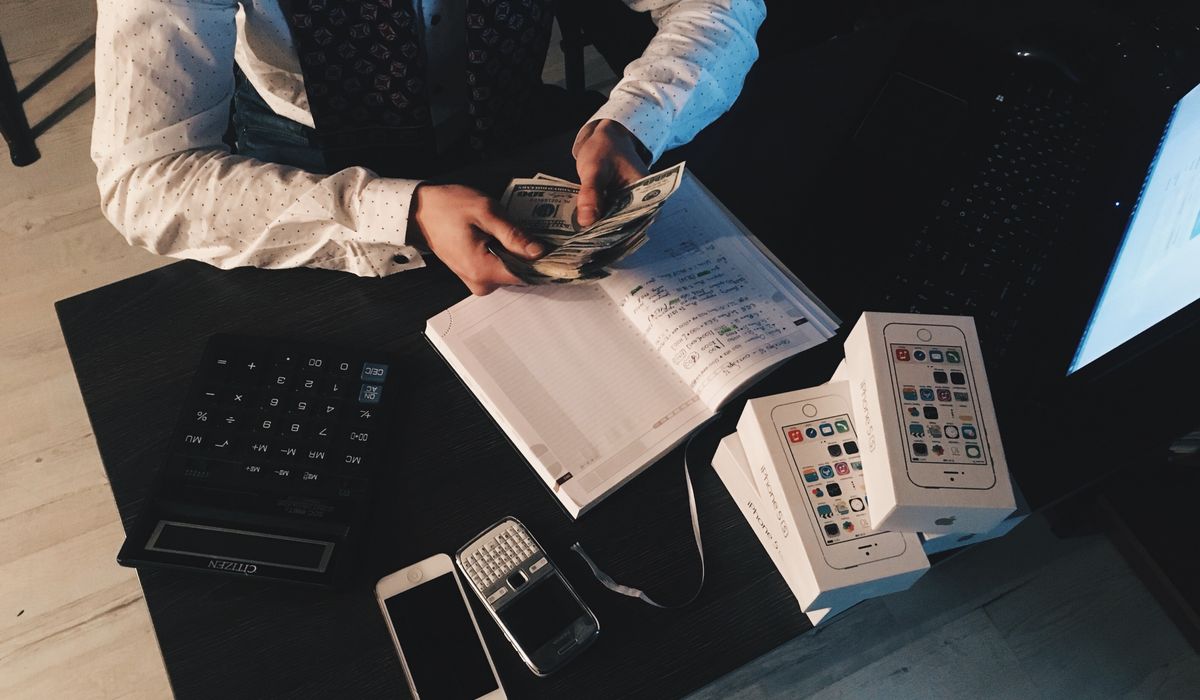 Masasında hesap makinesi ve notlarla ücret hesaplayan bir profesyonel