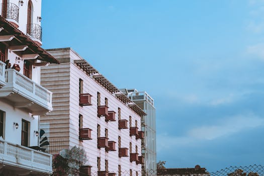 Low-angle view of an elegant building with balconies against a clear blue sky, perfect for architectural themes.