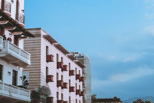 Free Low-angle view of an elegant building with balconies against a clear blue sky, perfect for architectural themes. Stock Photo