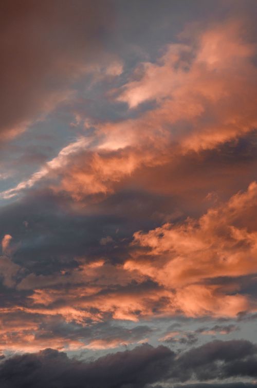 Free Dynamic sky at sunset with vibrant orange clouds creating a dramatic scene. Stock Photo