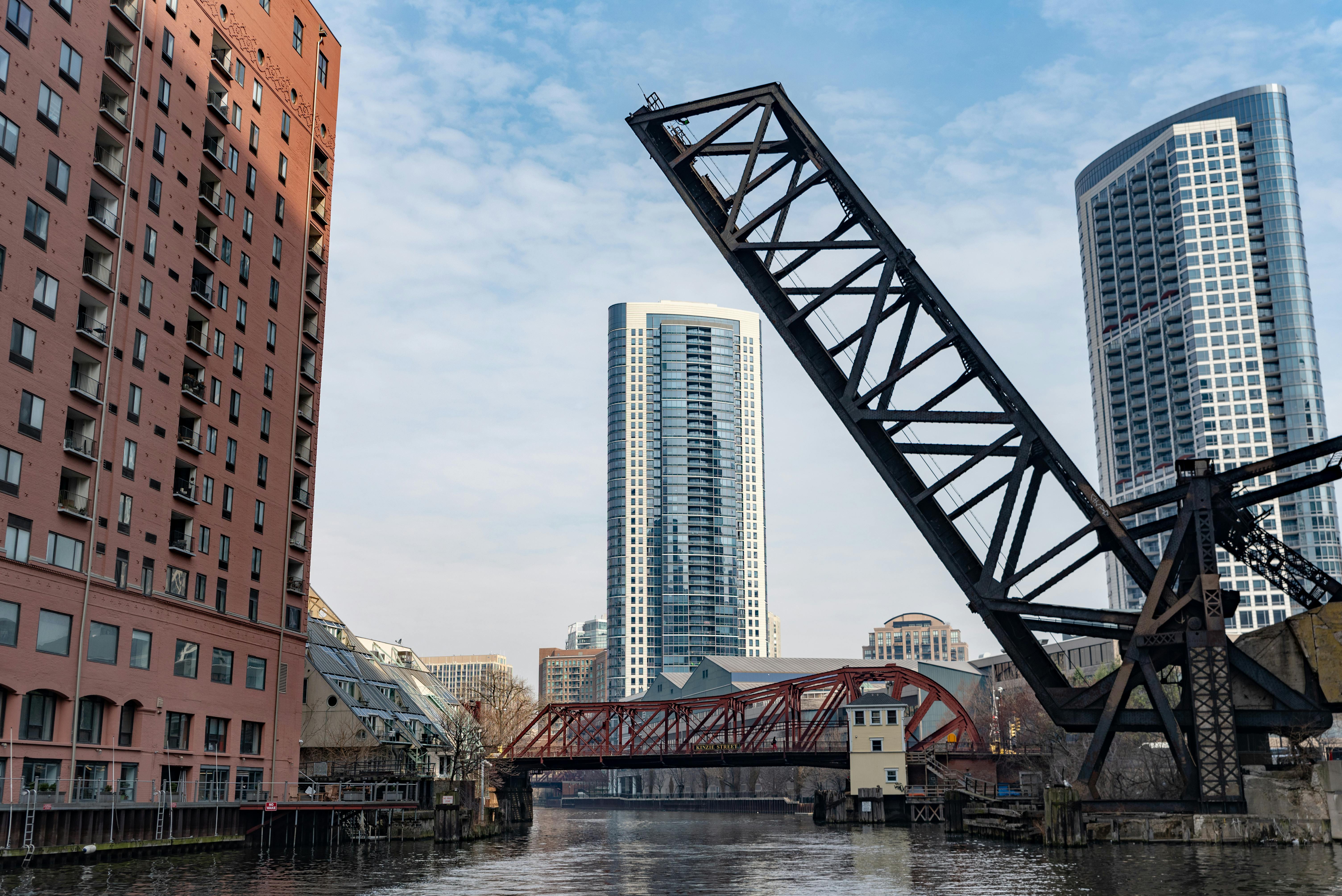 明亮的天空下，电梯桥、河流和现代摩天大楼构成了充满活力的城市景观