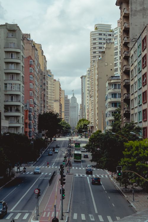 Free High angle street view of a bustling city with skyscrapers, traffic, and pedestrian crossings. Stock Photo
