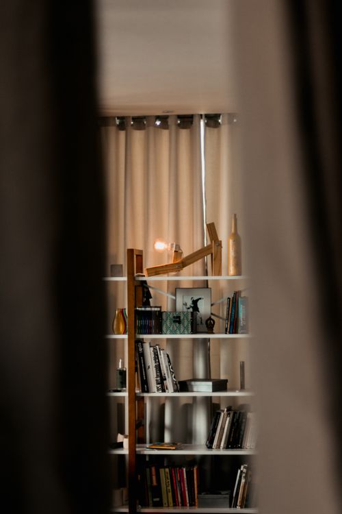 Free Intimate view of a modern bookcase filled with books and decor items, creating a cozy ambiance. Stock Photo