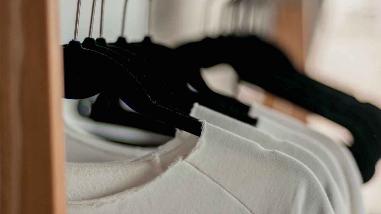 Simple maintainable capsule wardrobe Neatly hanging shirts representing a simple maintainable capsule wardrobe