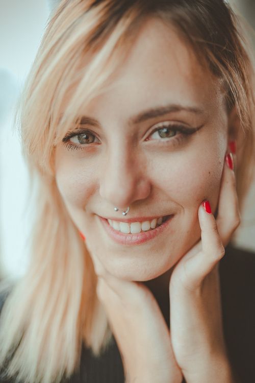 Free Close-up portrait of a smiling woman with a nose ring, exuding elegance and joy. Stock Photo