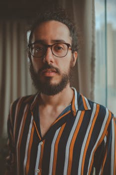 一位戴眼镜、留着胡须的时尚男子室内特写肖像