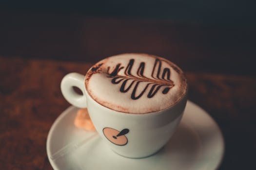 Close-up of a beautifully decorated latte with chocolate art in a ceramic cup on a saucer.