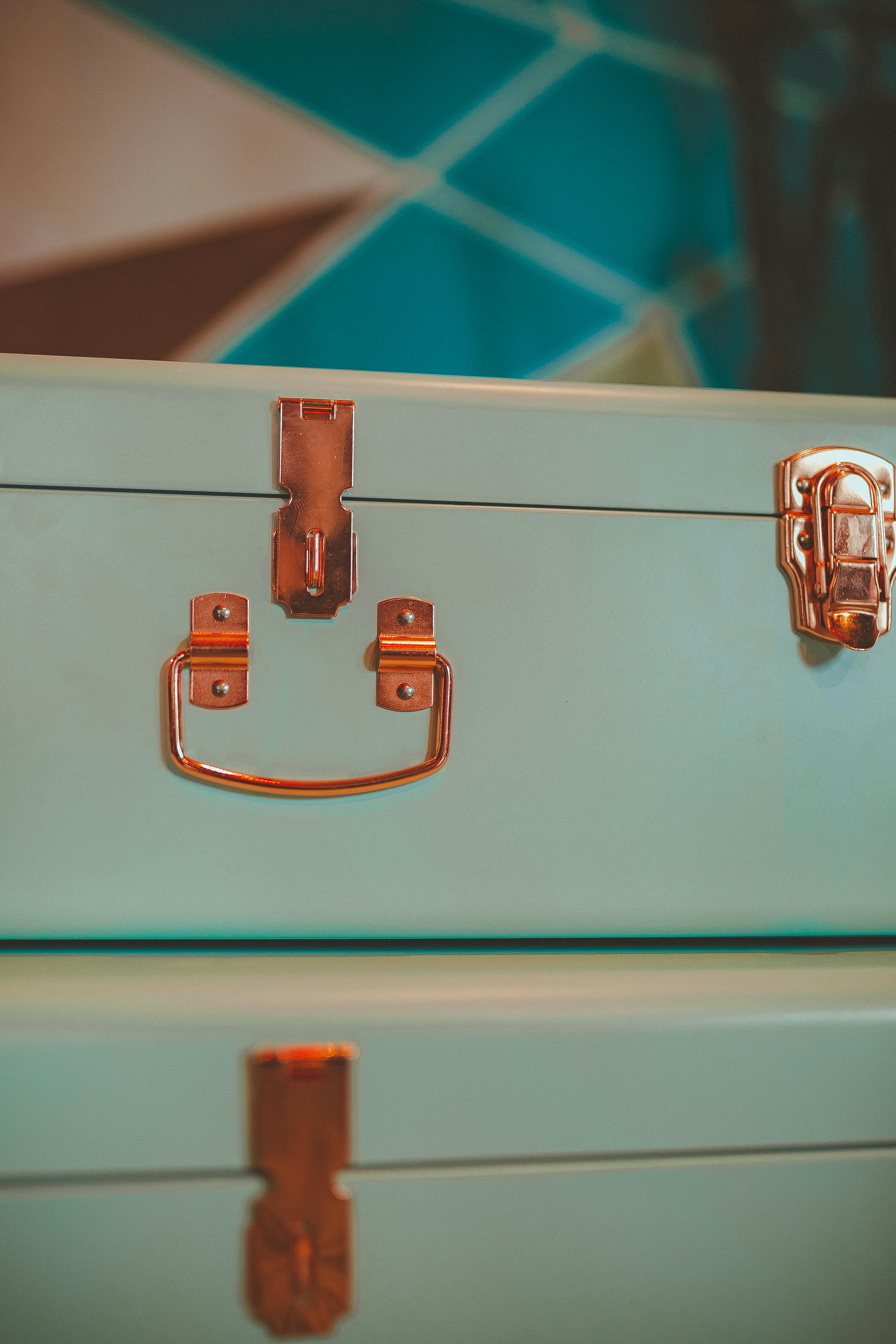 Detailed view of a retro blue-green metal cabinet with bronze handles.