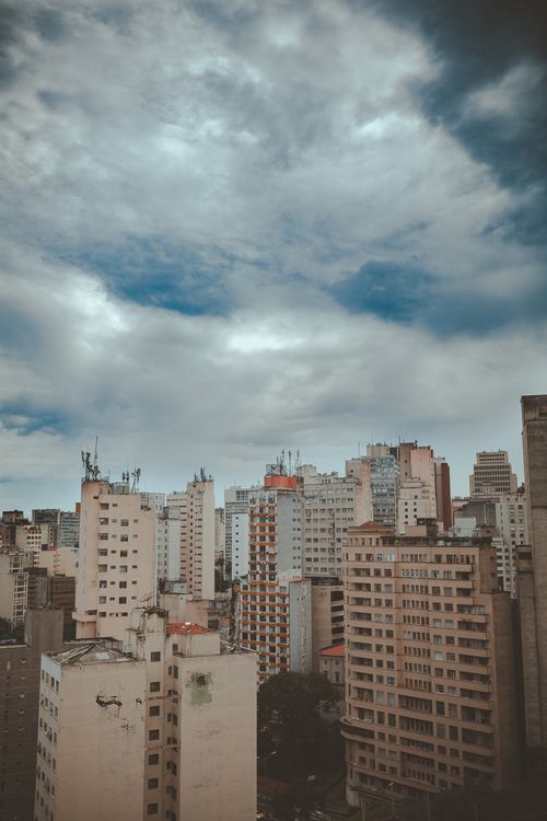 Free Urban skyline with skyscrapers under a dramatic cloudy sky, showcasing modern architecture. Stock Photo