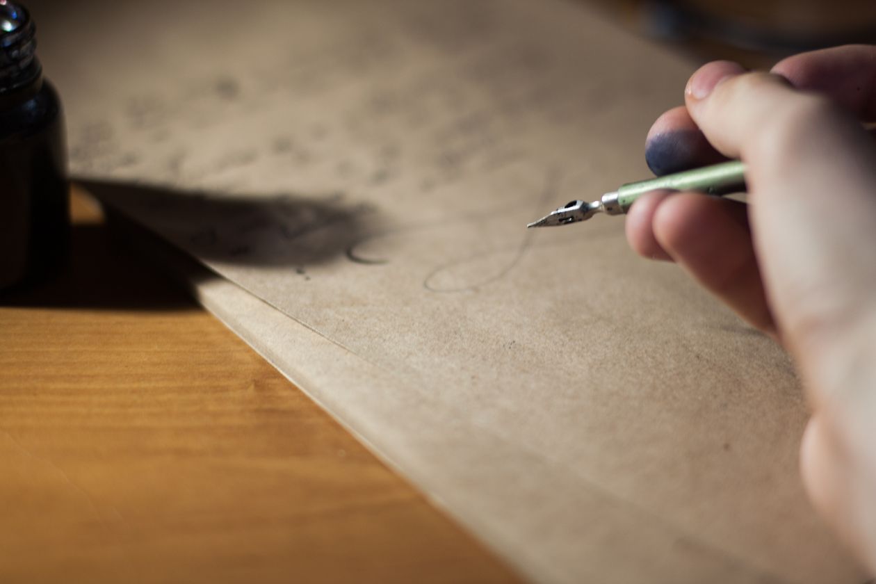 A hand writing with a fountain pen on vintage paper — fountain pen for handwritten study notes