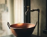 圣保罗室内环境中，一个带有复古水龙头的乡村铜盆特写