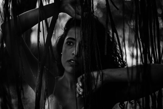 Artistic black and white portrait of a woman creating a mysterious and moody atmosphere.