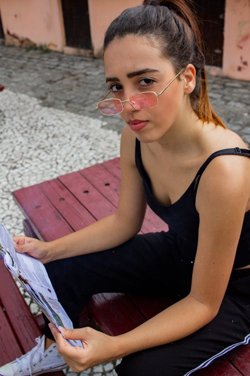Woman Holding Magazine Assis Sur Un Banc De Pique Nique