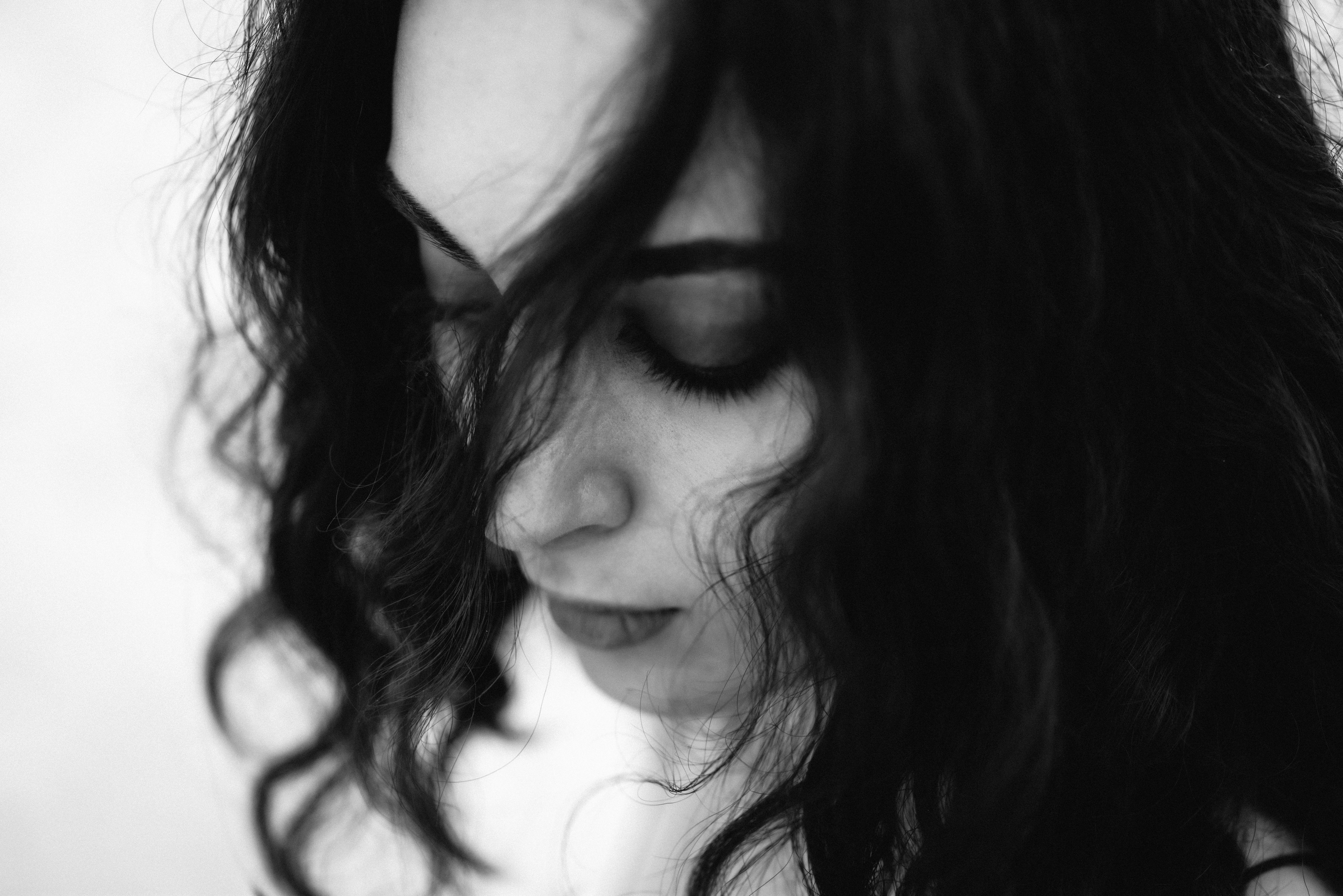 Black and white portrait of a young woman with closed eyes, showcasing serene elegance.