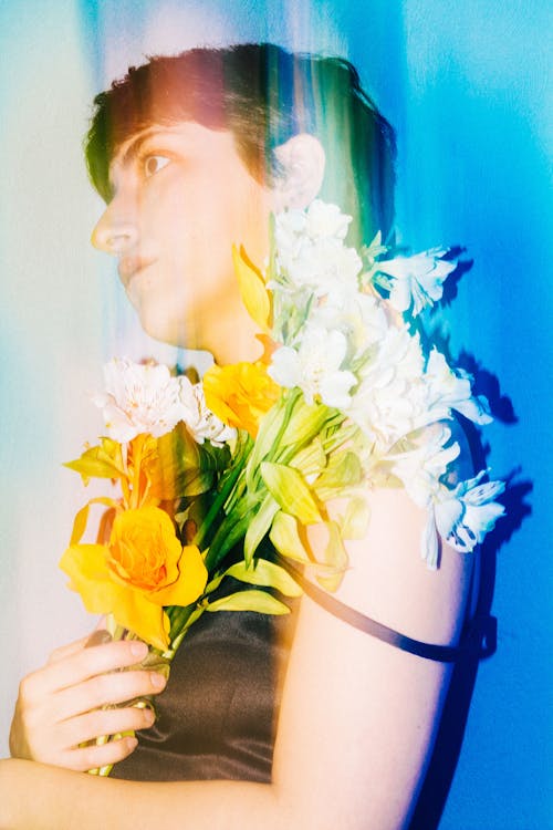 A woman holding flowers in front of a blue background