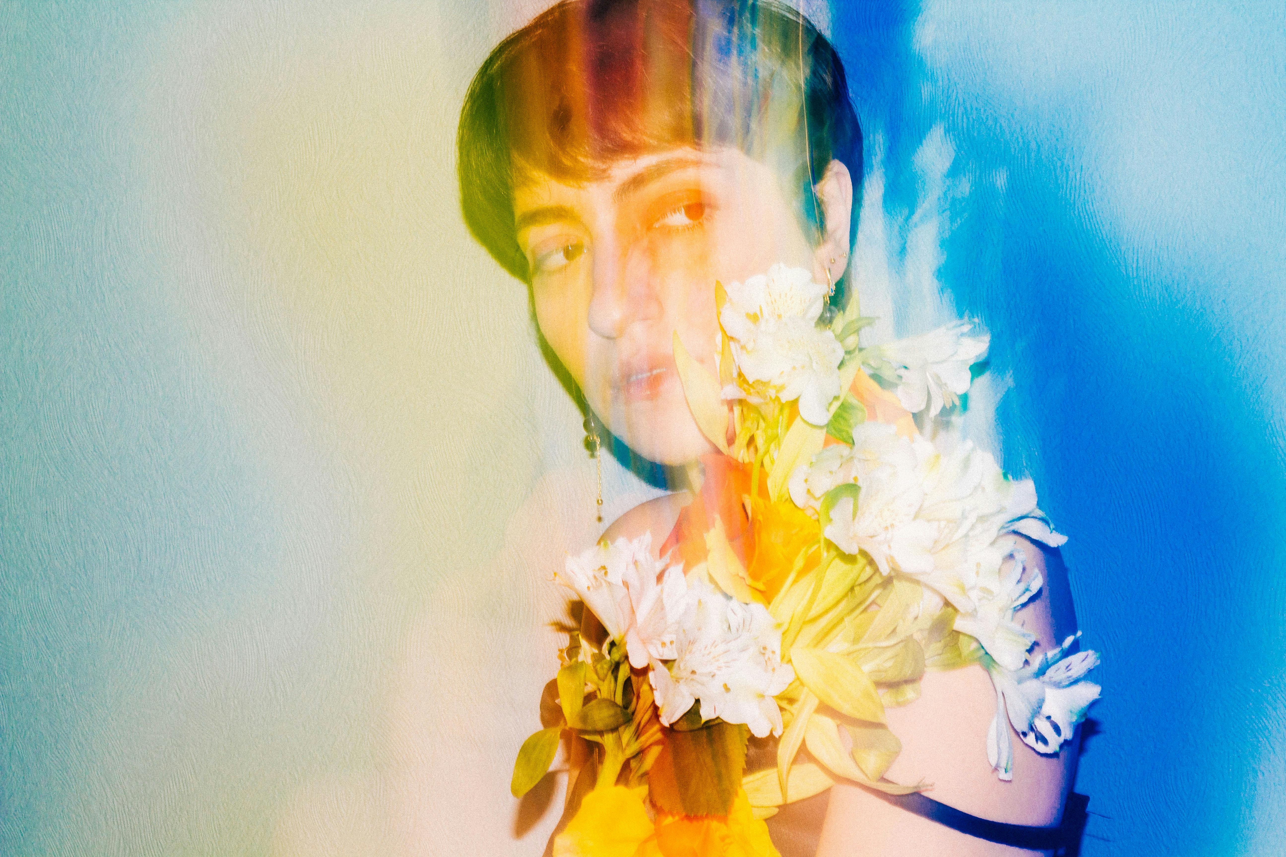 Colorful artistic portrait of a woman with flowers against a vibrant backdrop.