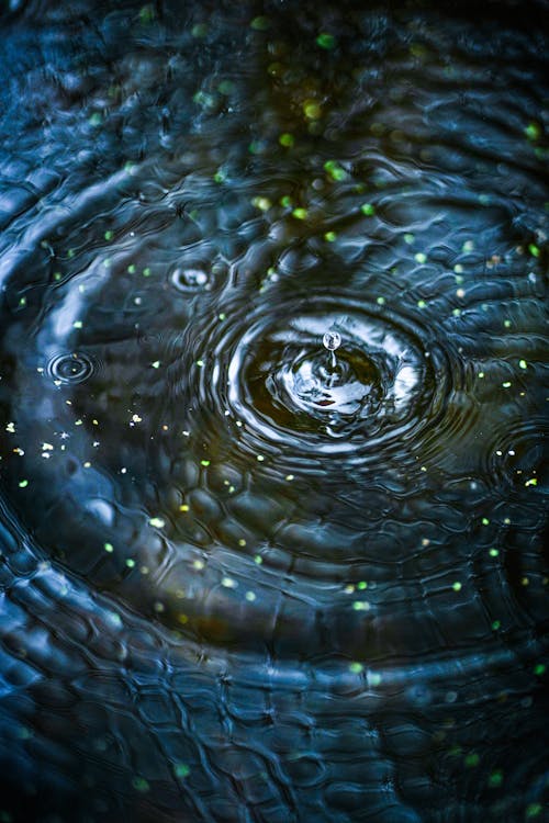 A close up of a water droplet with a green light