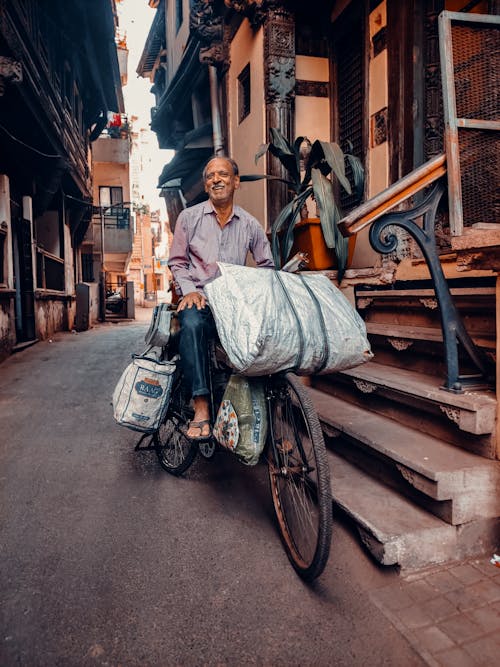 A man on a bicycle with a large bag on the back