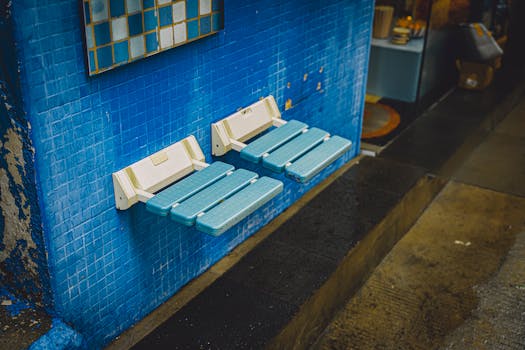 Urban setting with foldable seats against a blue tiled wall, showcasing modern design.