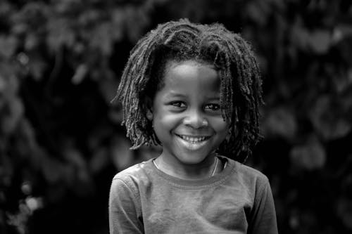 Foto En Escala De Grises De Un Niño Pequeño Con Cabello Trenzado