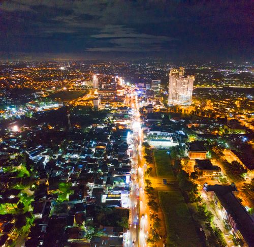 Free A captivating aerial view of a city at night with illuminated streets and bustling urban life. Stock Photo