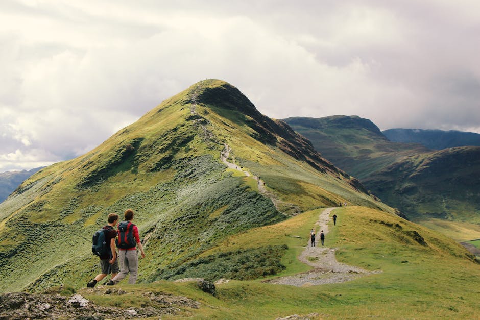 Hikers enjoy a scenic walk along a ridge in the stunning Lake District, England.