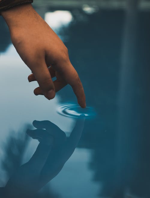 Person Touching Pool Of Water