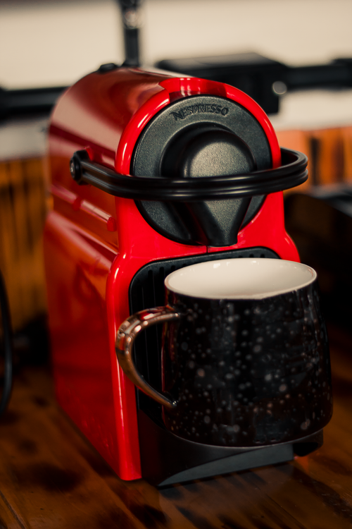 Free Close-up of a red coffee machine with a stylish black mug, perfect for cozy mornings. Stock Photo