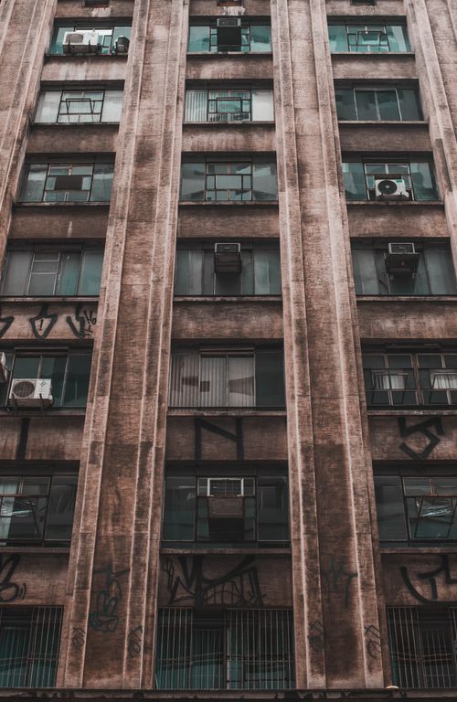 Free Close-up of an urban building facade showing multiple balconies and air conditioners. Stock Photo