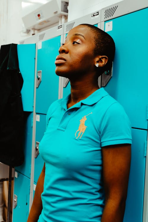 Woman Wearing Blue Us Polo Assn Polo Shirt in Front of Locker