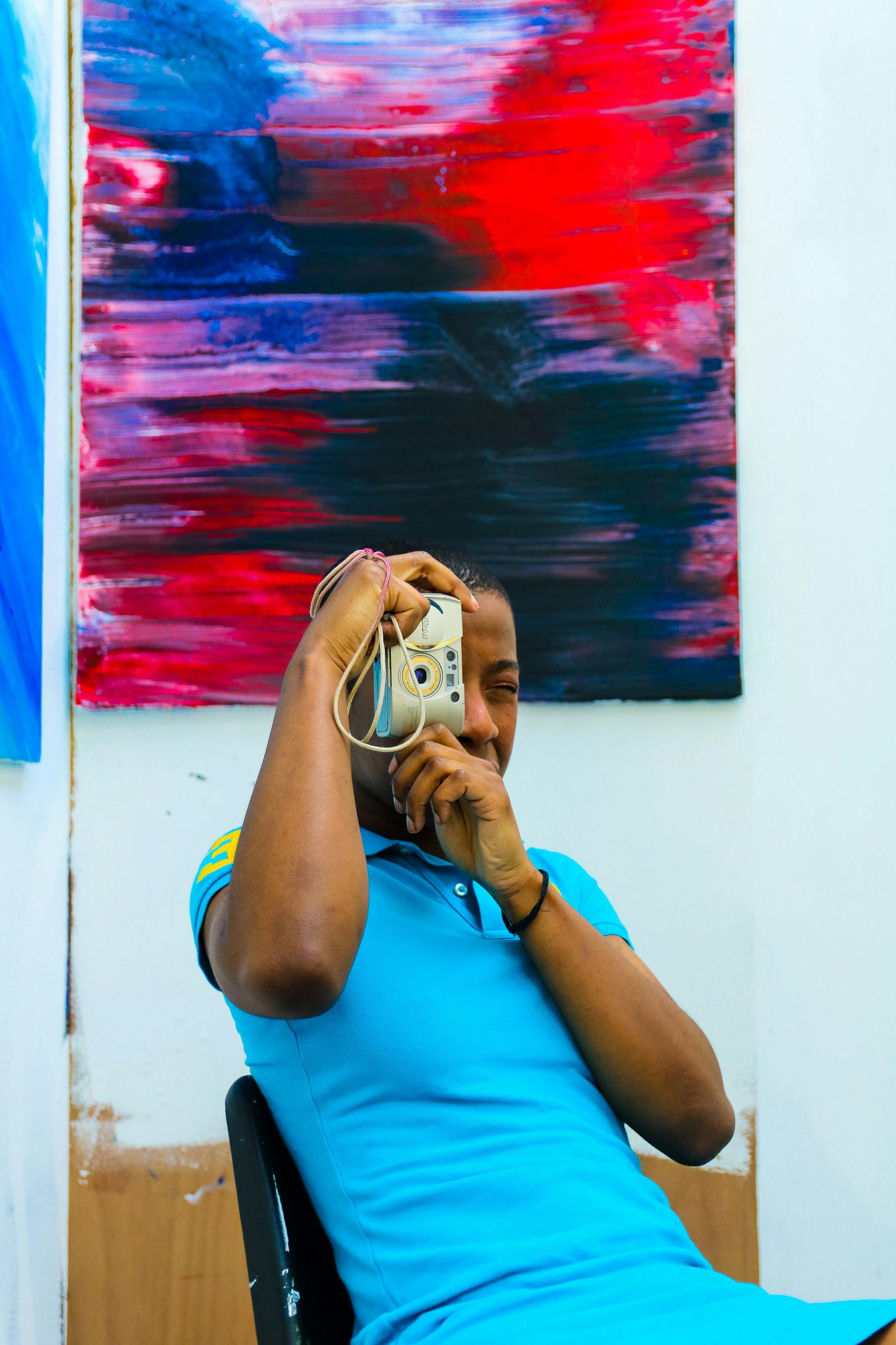 Gratis Pria Mengambil Foto Sambil Duduk Di Kursi Hitam Foto Stok