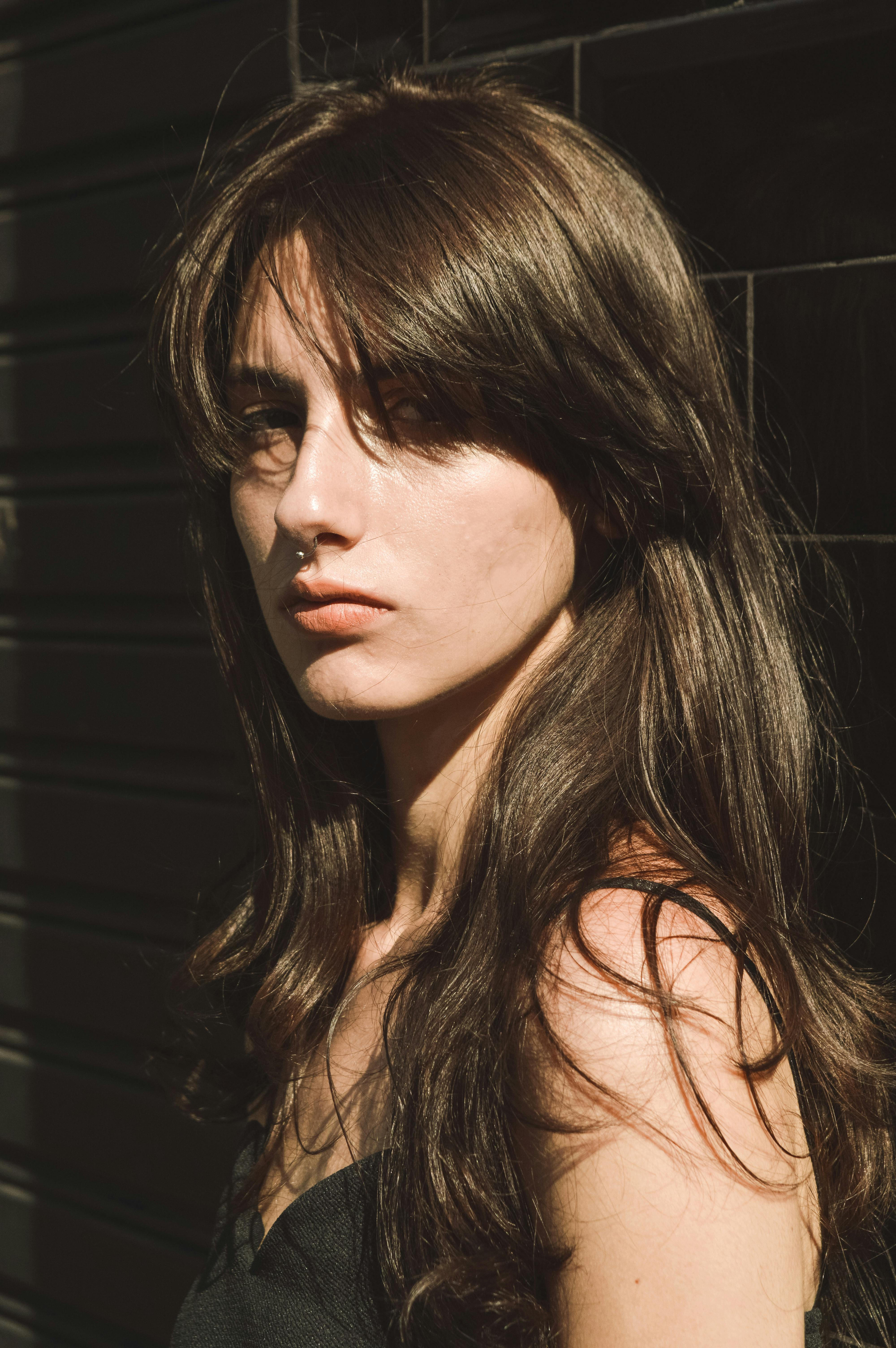 woman standing near black brick wall