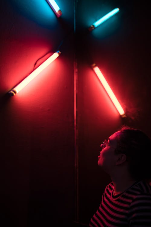 Man Looking Beside Four Red and Blue Led Lamps