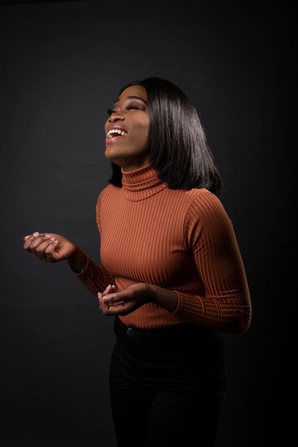 A joyful woman in a stylish outfit laughing, captured in a portrait setting. Perfect for fashion and lifestyle themes.