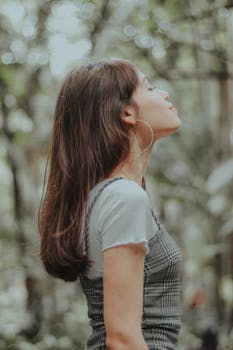 一位年轻女子在绿植环绕的户外享受着宁静的时光