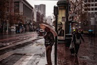 旧金山的鲍威尔街上，人们在雨天撑着伞行走