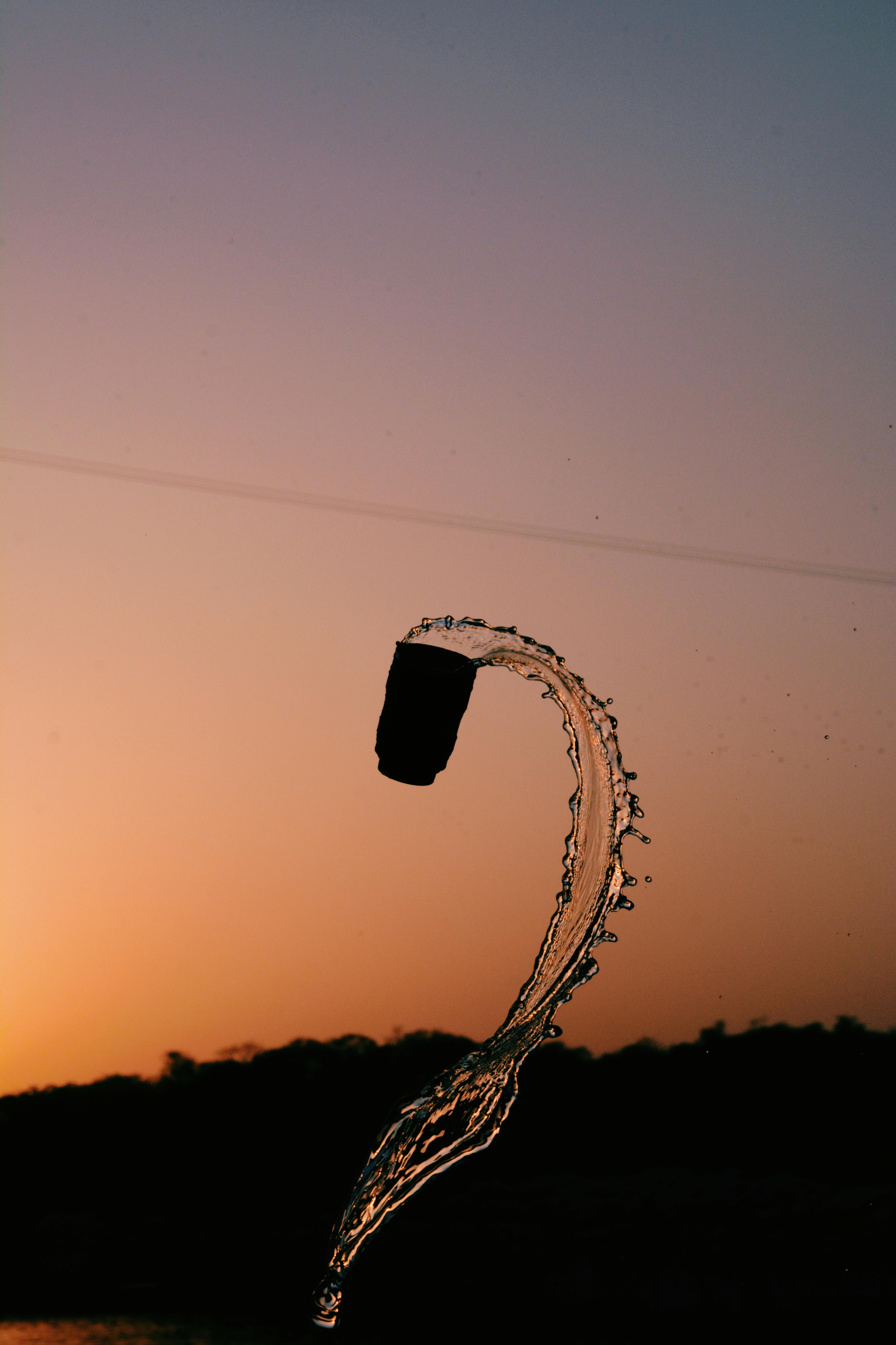在温暖的日落背景下，水花在空中飞溅出轮廓