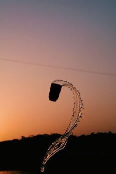 在温暖的日落背景下，水花在空中飞溅出轮廓