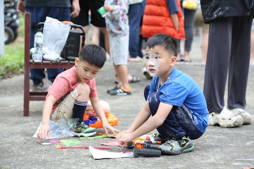 Two children playing with toys on the ground