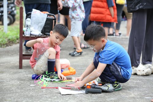 Free Two children playing with toys on the ground Stock Photo