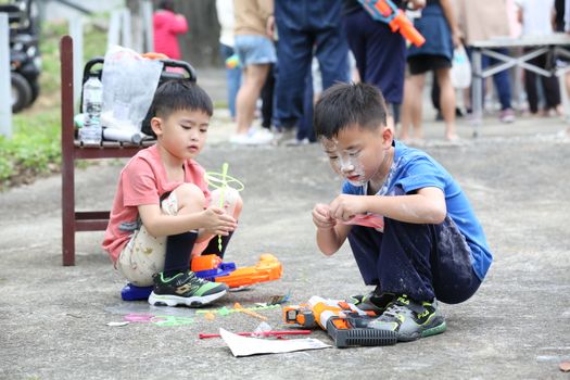 大宝和二宝一起分享玩具，笑容灿烂